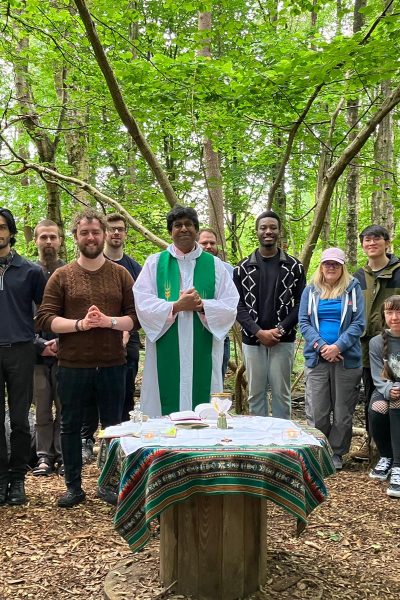 A group of parishioners gather in the centre's woodland with a priest for Mass