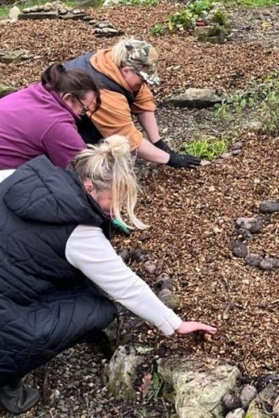 A community group works to prepare a herb garden at the centre