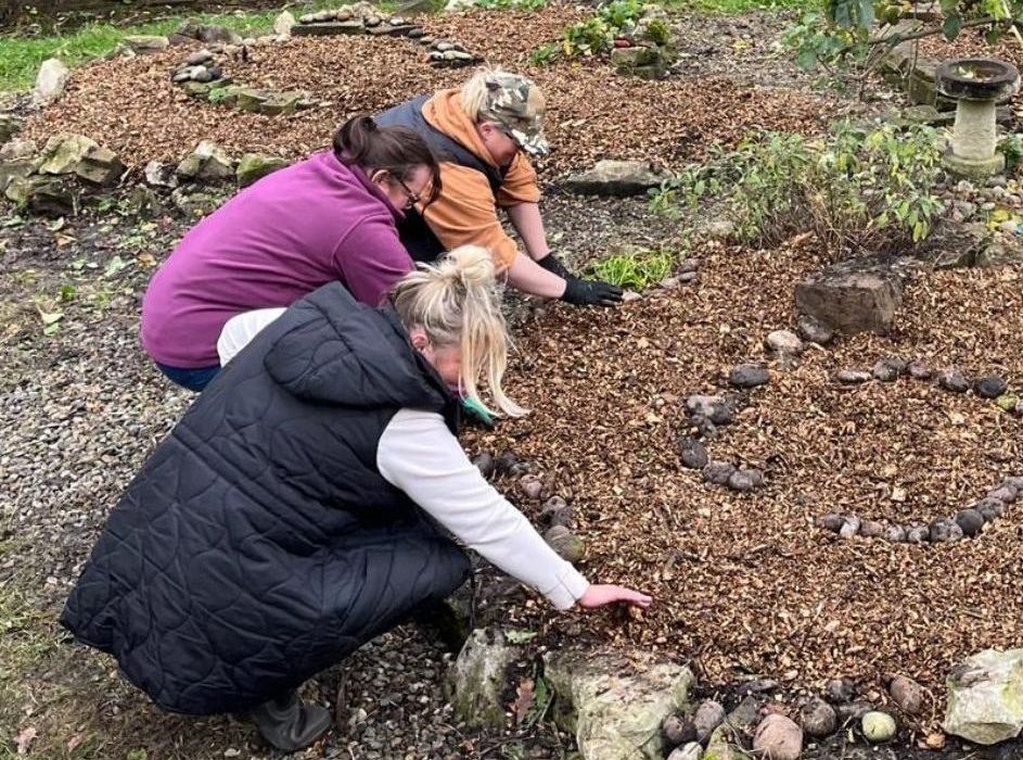 A community group works to prepare a herb garden at the centre